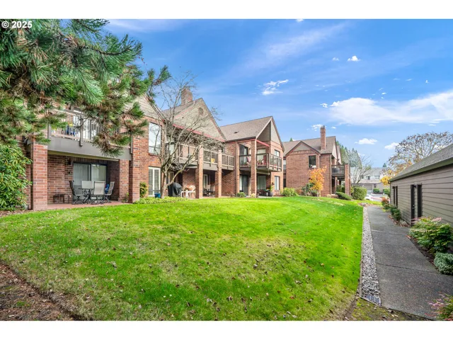 a view of a big house with a big yard and large trees
