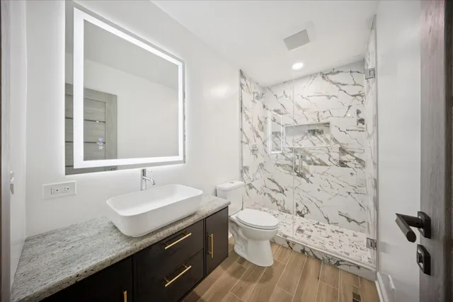 a bathroom with a toilet a sink and mirror