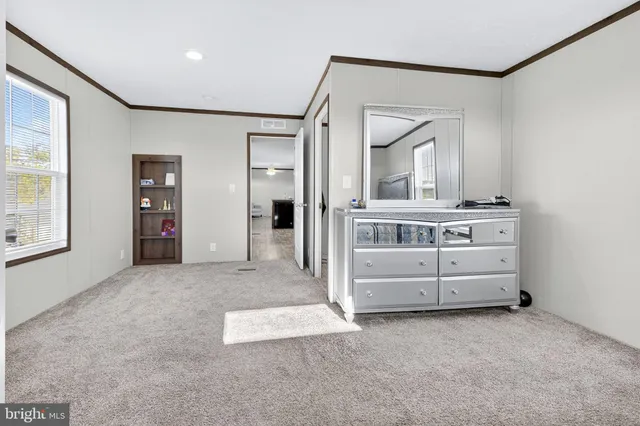 a spacious bedroom with a bed and a mirror