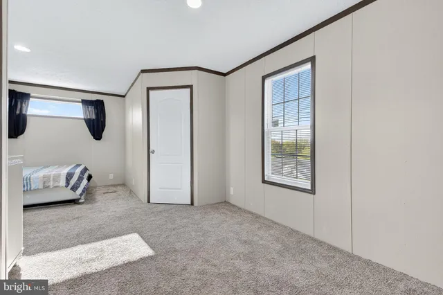 a bedroom with a bed a window and painting on the wall