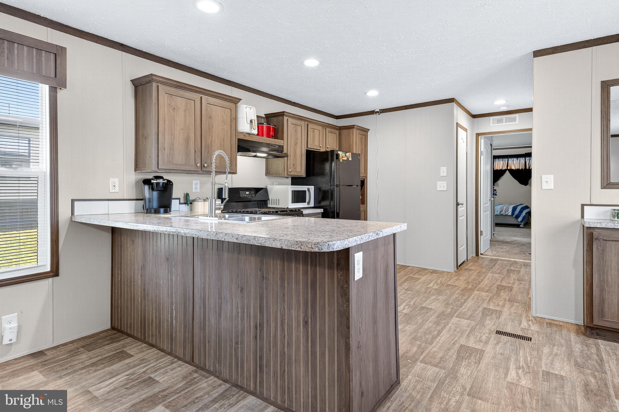 48 Dallas Drive Grantville, PA 17028 - Photo 5 of 30 a kitchen with kitchen island granite countertop a sink cabinets and wooden floor