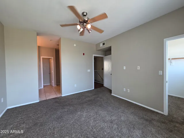 a view of an empty room with a ceiling fan