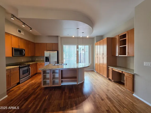 a view of kitchen with microwave a stove and wooden floor