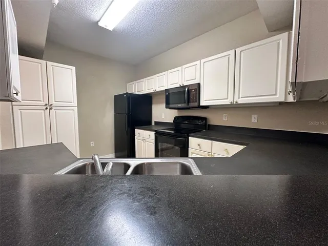 a kitchen with stainless steel appliances granite countertop a sink a stove and a microwave