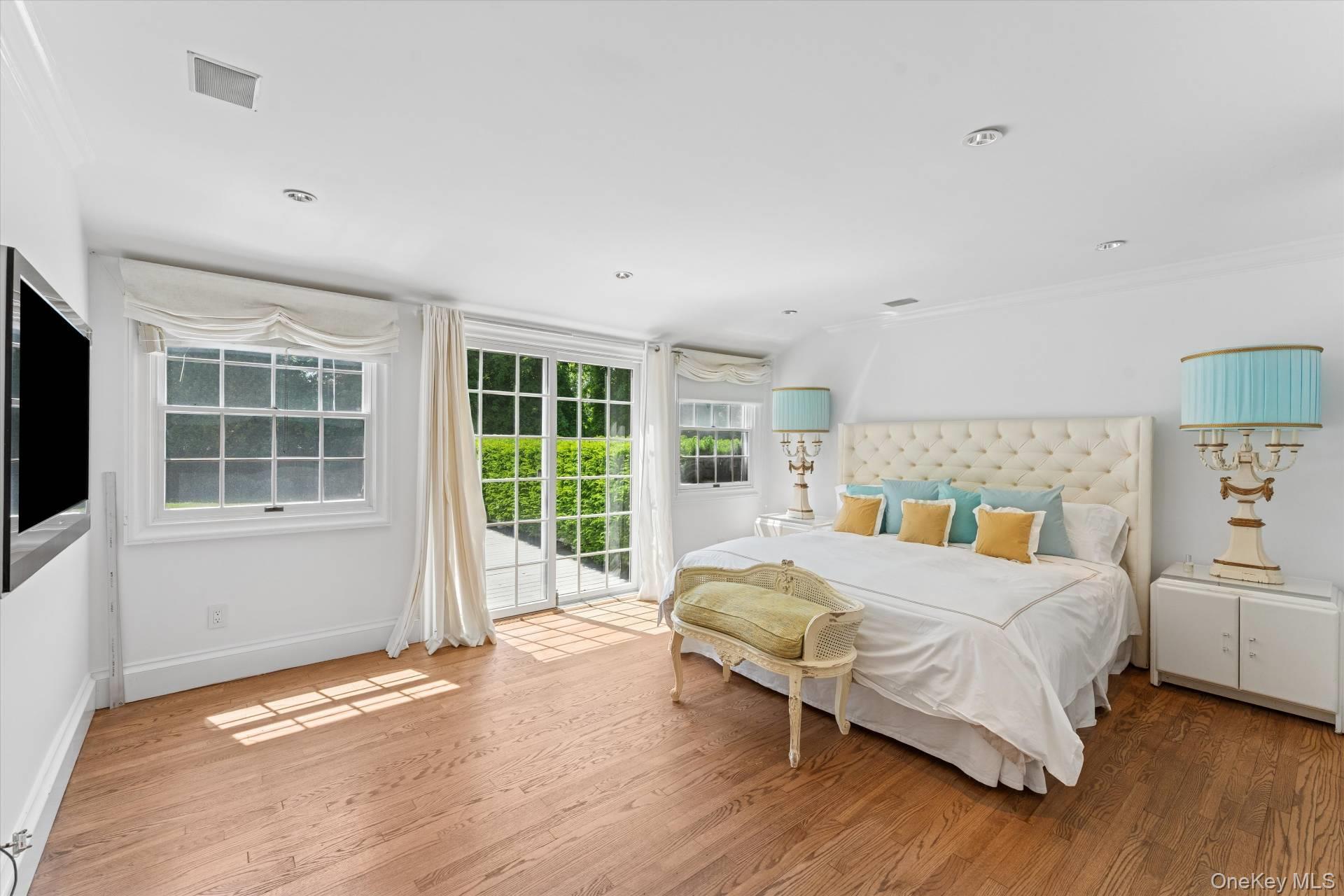 129 Oneck Lane Westhampton Beach, NY 11978 - Photo 14 of 32 a bedroom with a bed and a large window