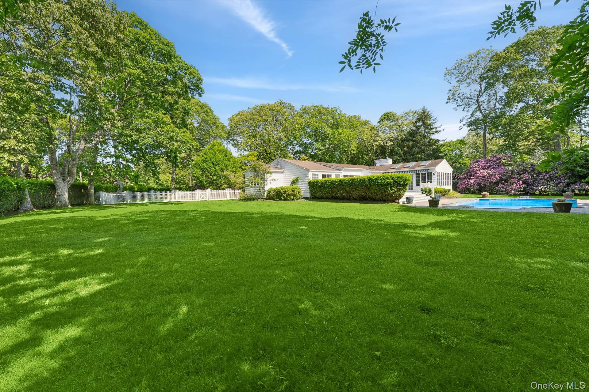 129 Oneck Lane Westhampton Beach, NY 11978 - Photo 26 of 32 a view of a garden with a bench