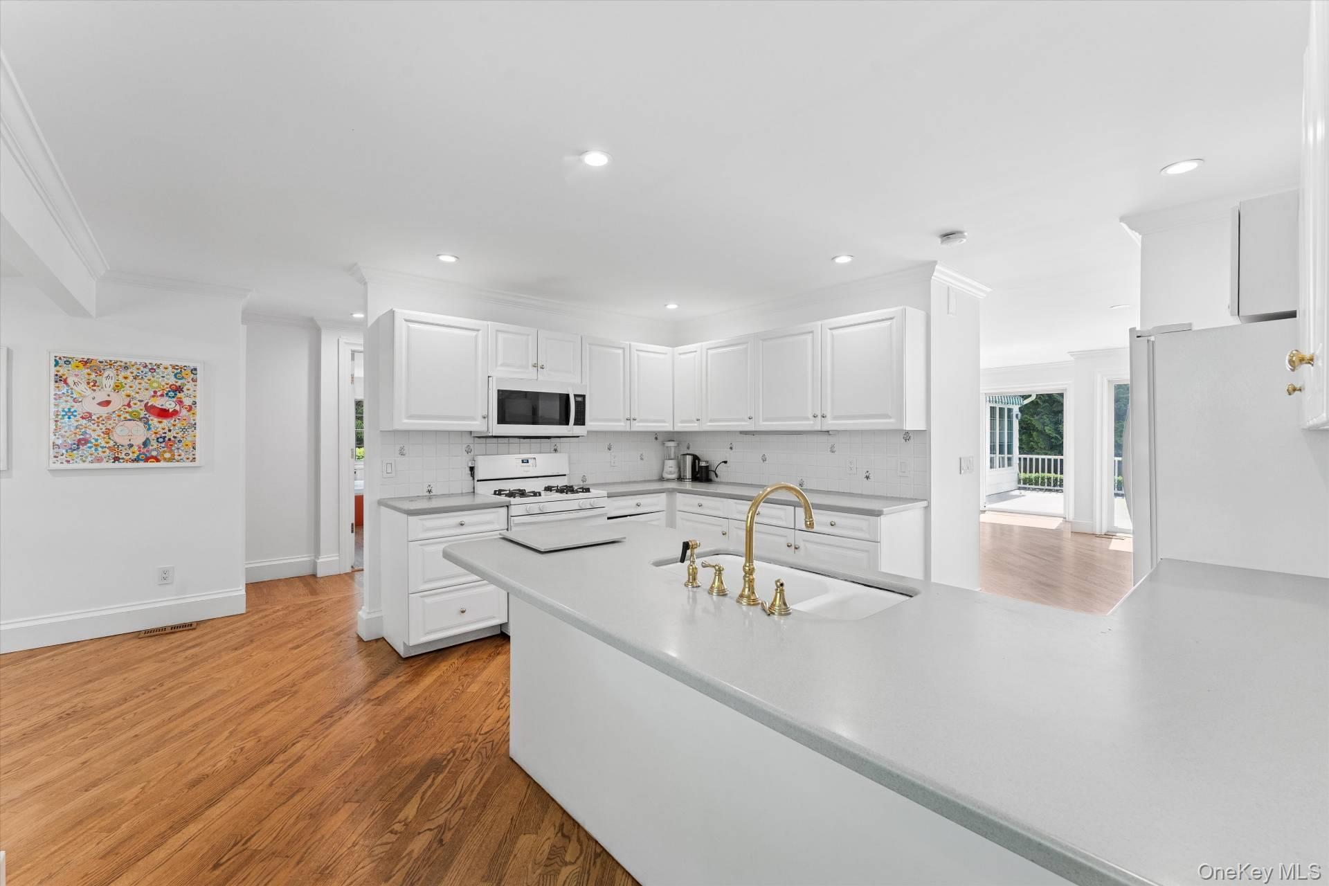 129 Oneck Lane Westhampton Beach, NY 11978 - Photo 3 of 32 a view of a kitchen with kitchen island a sink stainless steel appliances and white cabinets