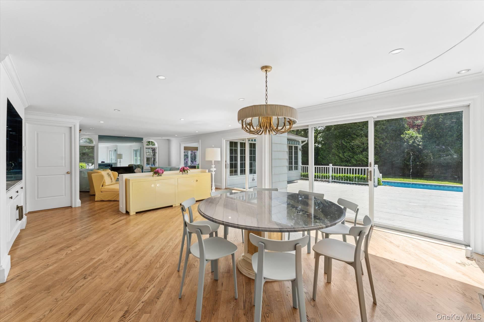 129 Oneck Lane Westhampton Beach, NY 11978 - Photo 7 of 32 a view of a dining room with furniture wooden floor and chandelier