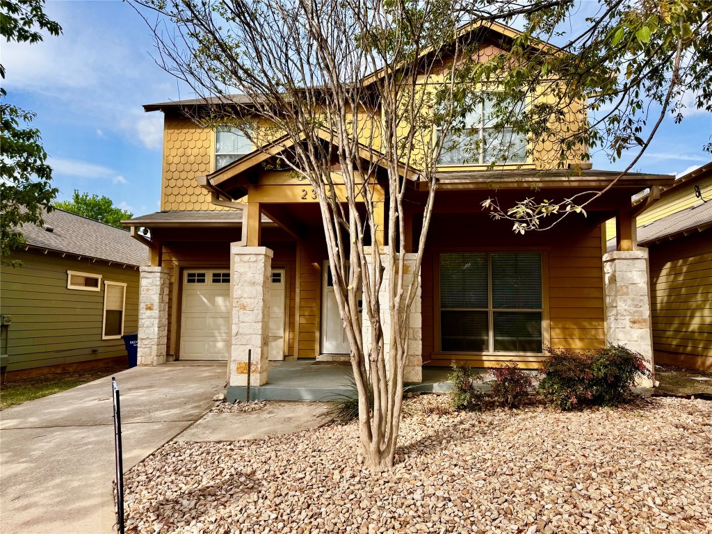 a front view of a house with a tree