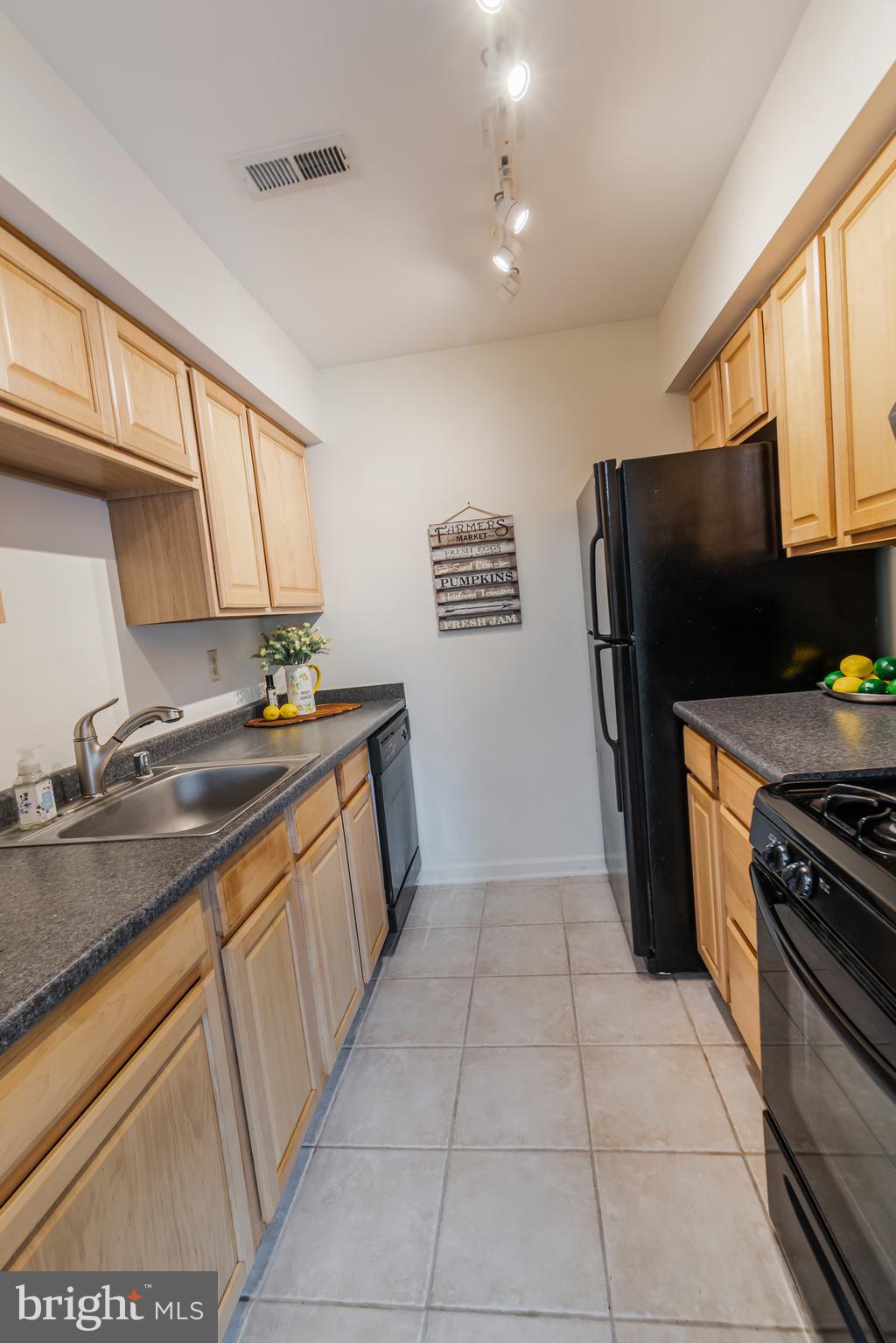 106 Mountain Road, Unit 1A Pasadena, MD 21122 - Photo 10 of 29 a kitchen with a sink a refrigerator a stove top oven a washer and dryer