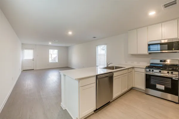 a kitchen with stainless steel appliances granite countertop a sink stove and refrigerator