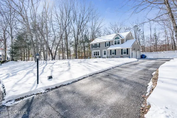 a view of a white house with a yard covered in snow