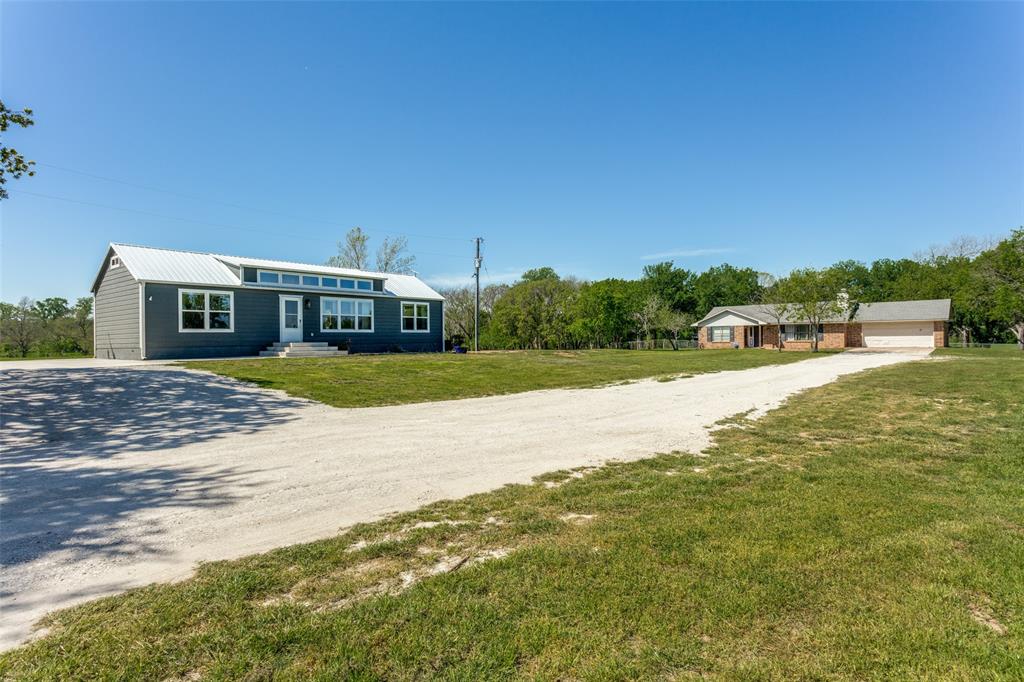 a view of a house with a yard and lake view