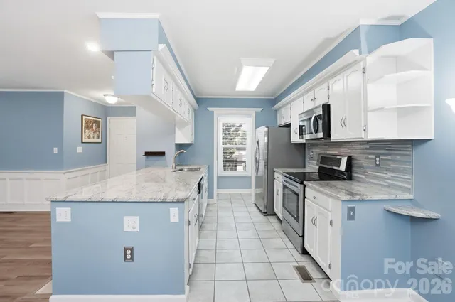 a kitchen with stainless steel appliances granite countertop a stove a sink and a microwave