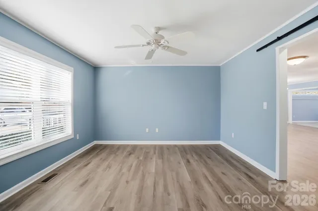 a view of a room with wooden floor and white walls