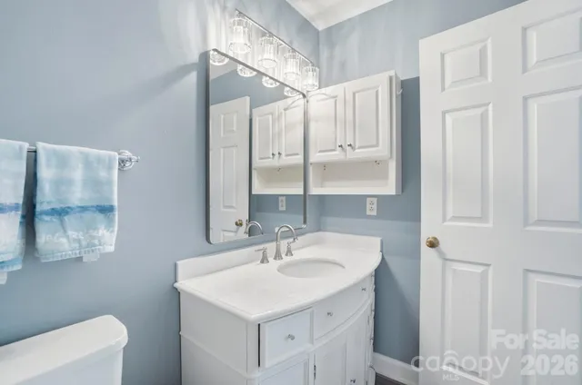 a bathroom with a sink a toilet and a mirror