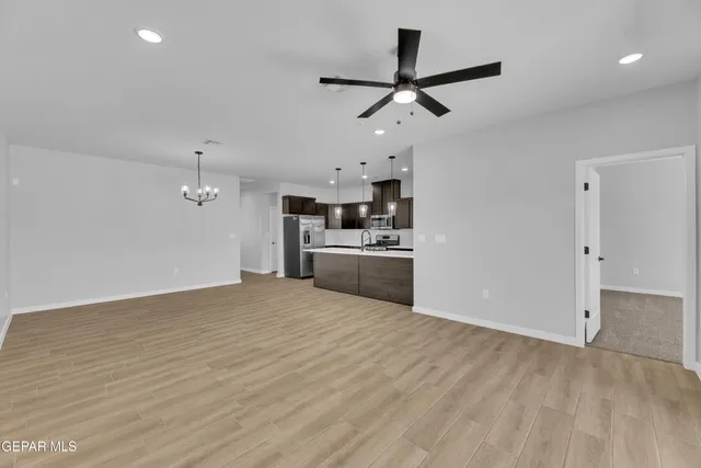a view of a kitchen with a sink a ceiling fan and stainless steel appliances