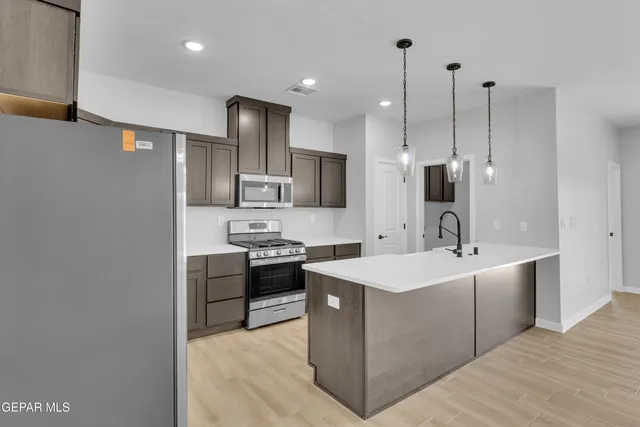 a kitchen with stainless steel appliances a sink stove and refrigerator