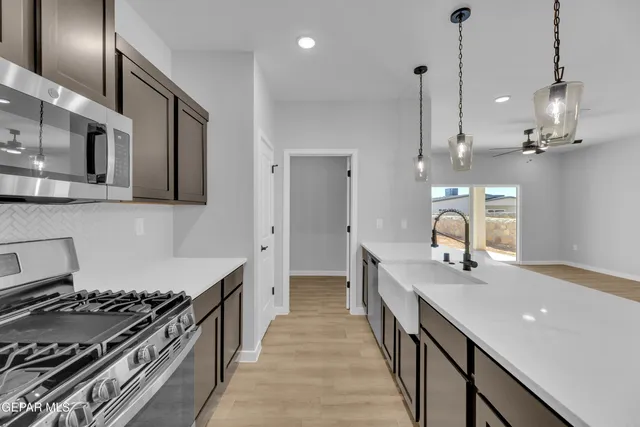 a kitchen with stainless steel appliances granite countertop a sink a stove and a wooden floors
