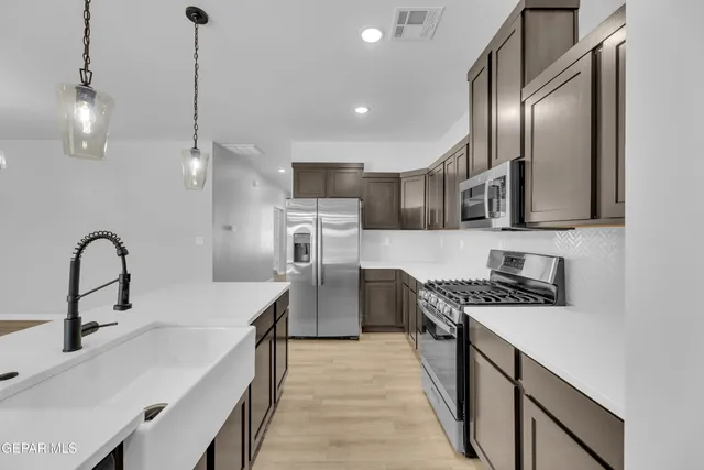 a kitchen with stainless steel appliances a sink stove and refrigerator
