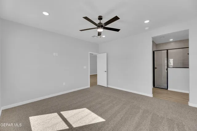 a view of an empty room with a ceiling fan