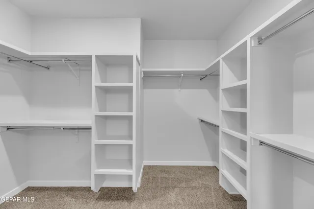 a view of walk in closet with empty racks