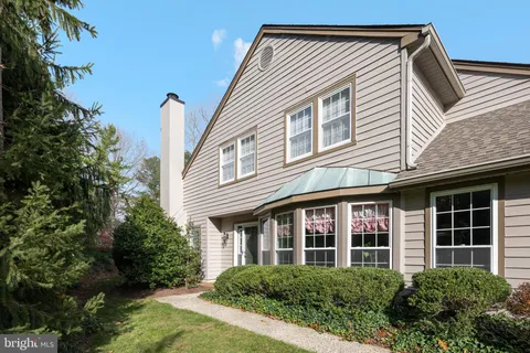a view of a white house next to a yard