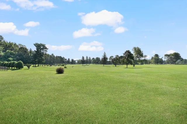 a view of a fountain in front of a house with a big yard