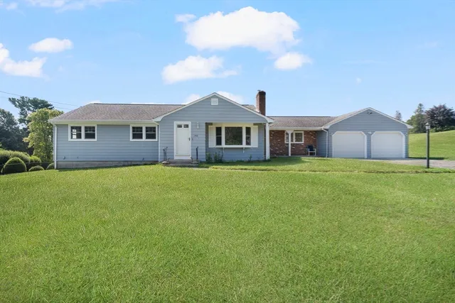 a front view of house with yard and green space