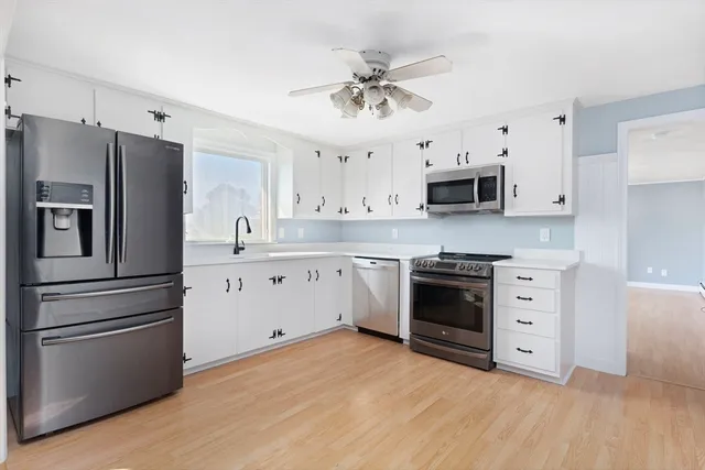 a kitchen with stainless steel appliances white cabinets and a refrigerator