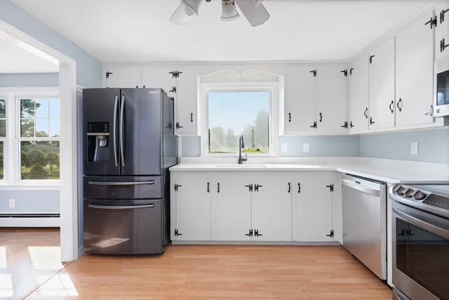 a kitchen with cabinets stainless steel appliances and a window