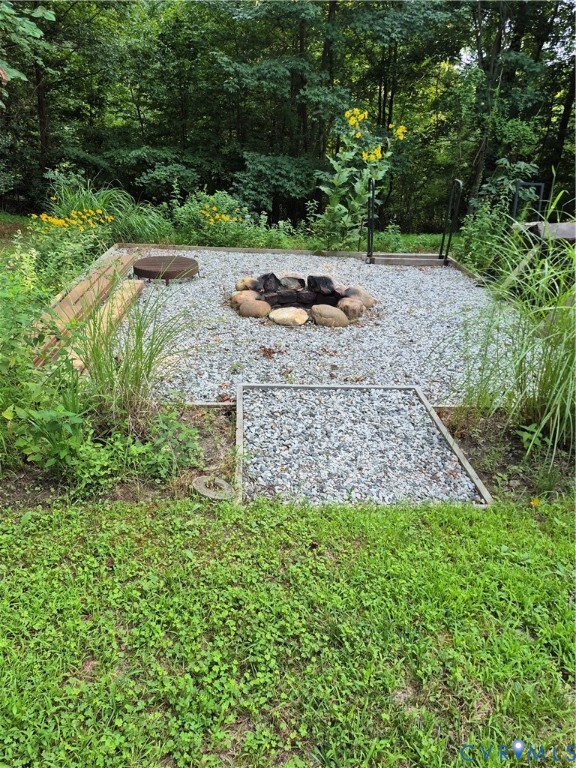 15731 Cooks Mill Road Lanexa, VA 23089 - Photo 4 of 14 Gravel fire pit area bordered by natural landscapi