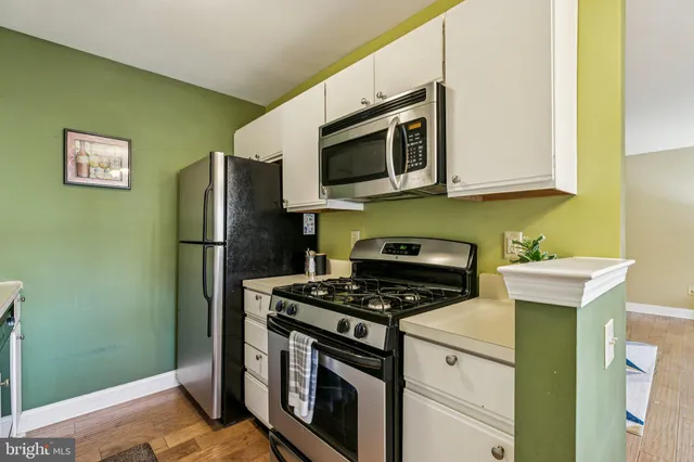 a kitchen with stainless steel appliances granite countertop a refrigerator and a stove top oven