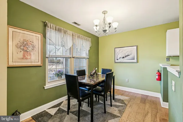 a view of a dining room with furniture a chandelier and a window