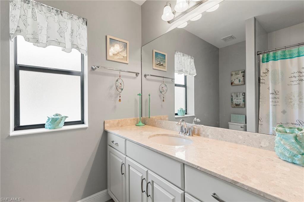 1350 Kendari Terrace Naples, FL 34113 - Photo 23 of 47 Bathroom featuring healthy amount of natural light, vanity, and curtained shower