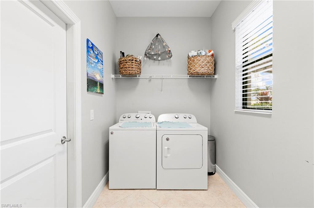 1350 Kendari Terrace Naples, FL 34113 - Photo 26 of 47 Washroom with light tile patterned floors and washing machine and clothes dryer