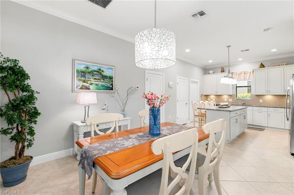 1350 Kendari Terrace Naples, FL 34113 - Photo 7 of 47 Dining area featuring crown molding, a chandelier, recessed lighting, and light tile patterned flooring