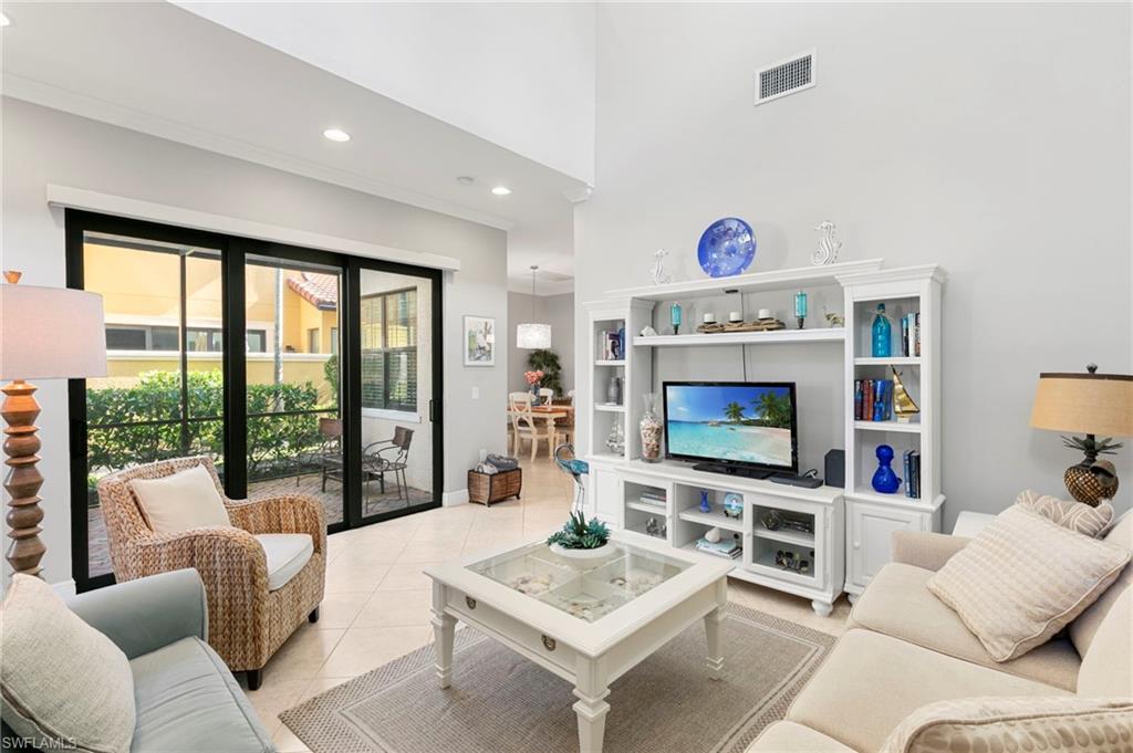 1350 Kendari Terrace Naples, FL 34113 - Photo 8 of 47 Living room with tile patterned flooring, recessed lighting, ornamental molding, and a towering ceiling