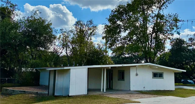 a view of a small house with yard
