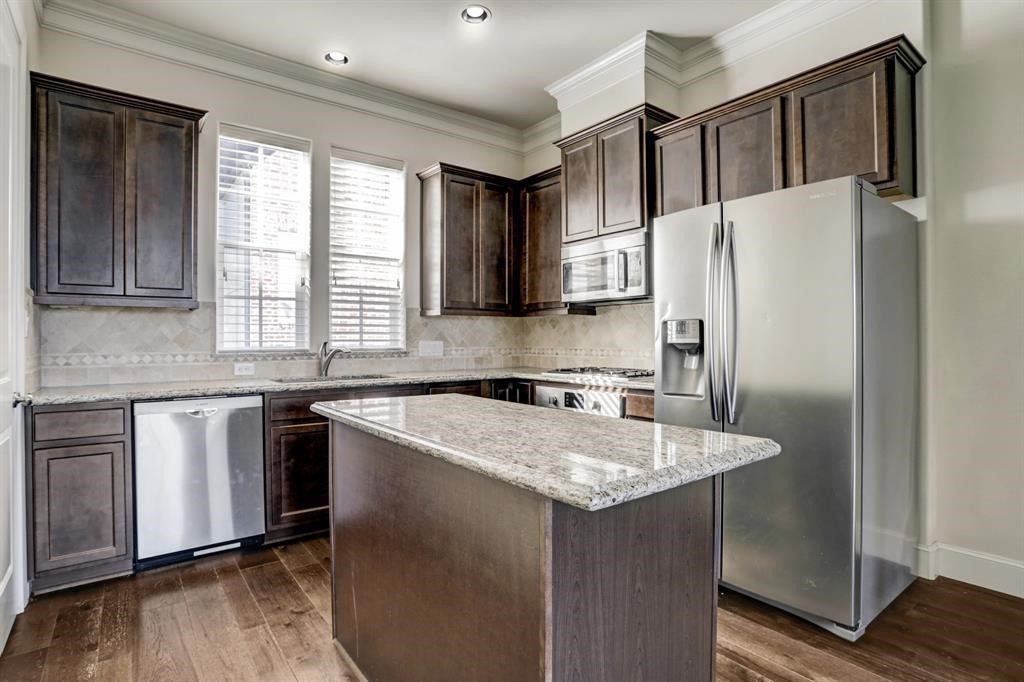 9676 Knight Road Houston, TX 77045 - Photo 4 of 11 a kitchen with stainless steel appliances granite countertop a refrigerator a sink and a stove