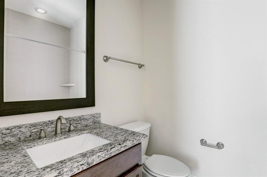 9676 Knight Road Houston, TX 77045 - Photo 8 of 11 a bathroom with a granite countertop sink toilet and mirror