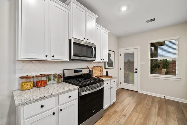 a kitchen with granite countertop a sink a stove and wooden cabinets