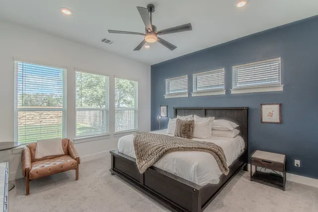 a bedroom with a large bed and ceiling fan