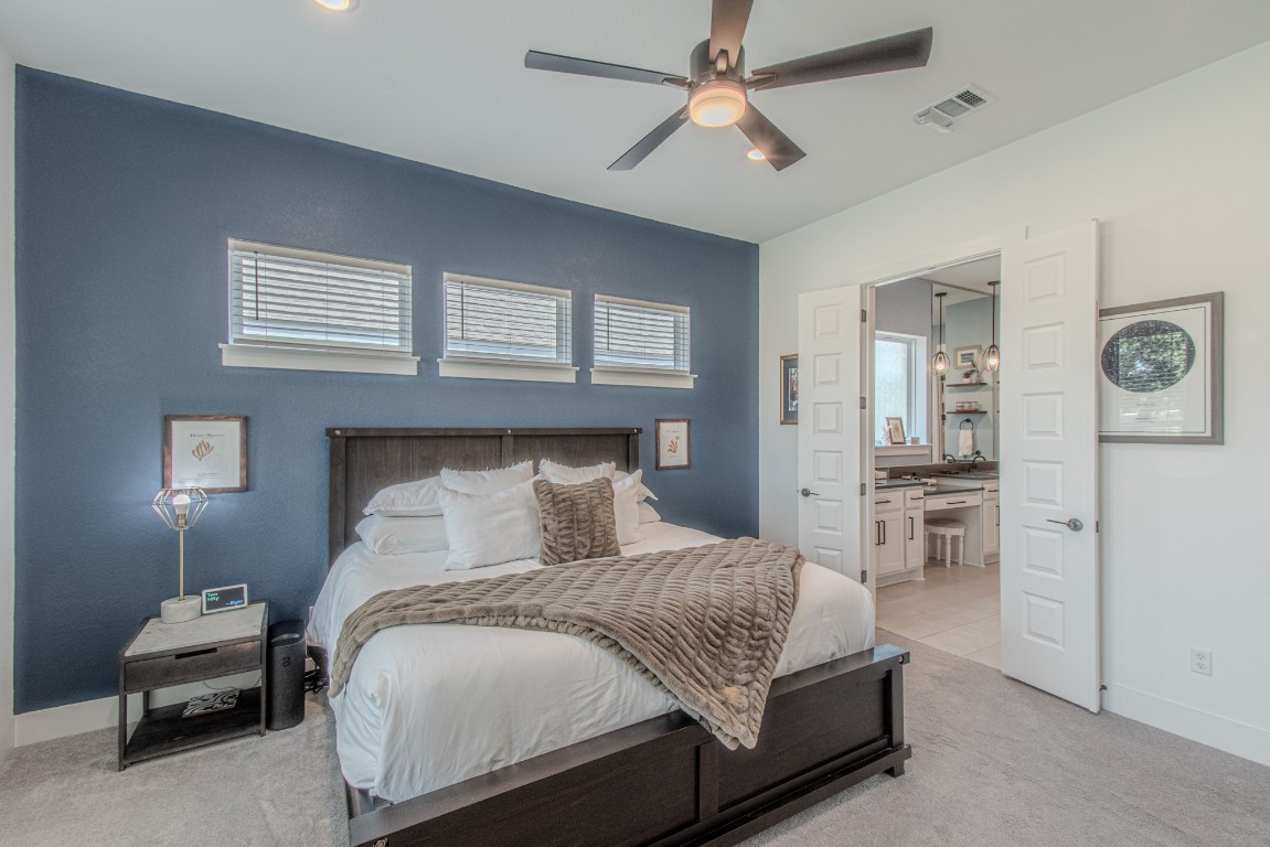 308 Millbend Road Georgetown, TX 78633 - Photo 14 of 40 a bedroom with a large bed and ceiling fan