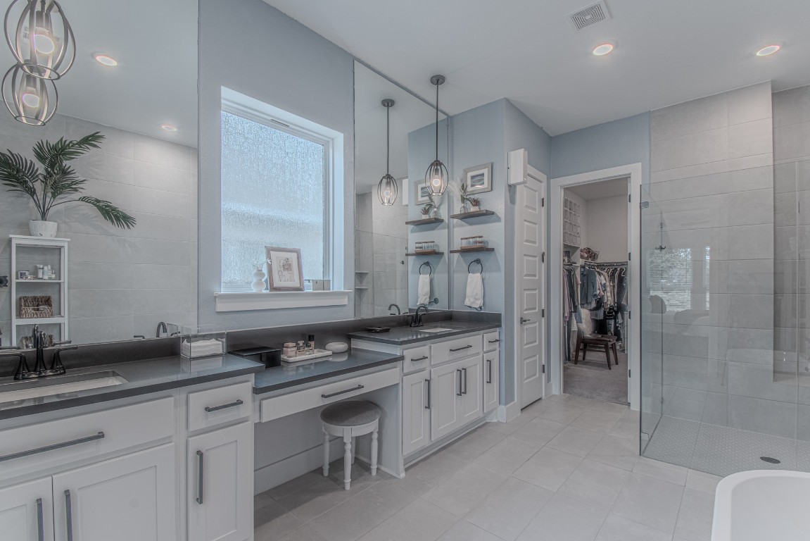 308 Millbend Road Georgetown, TX 78633 - Photo 16 of 40 a spacious bathroom with a granite countertop sink a toilet a mirror and shower