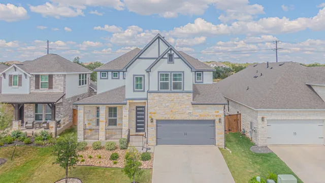 a aerial view of a brick house next to a yard