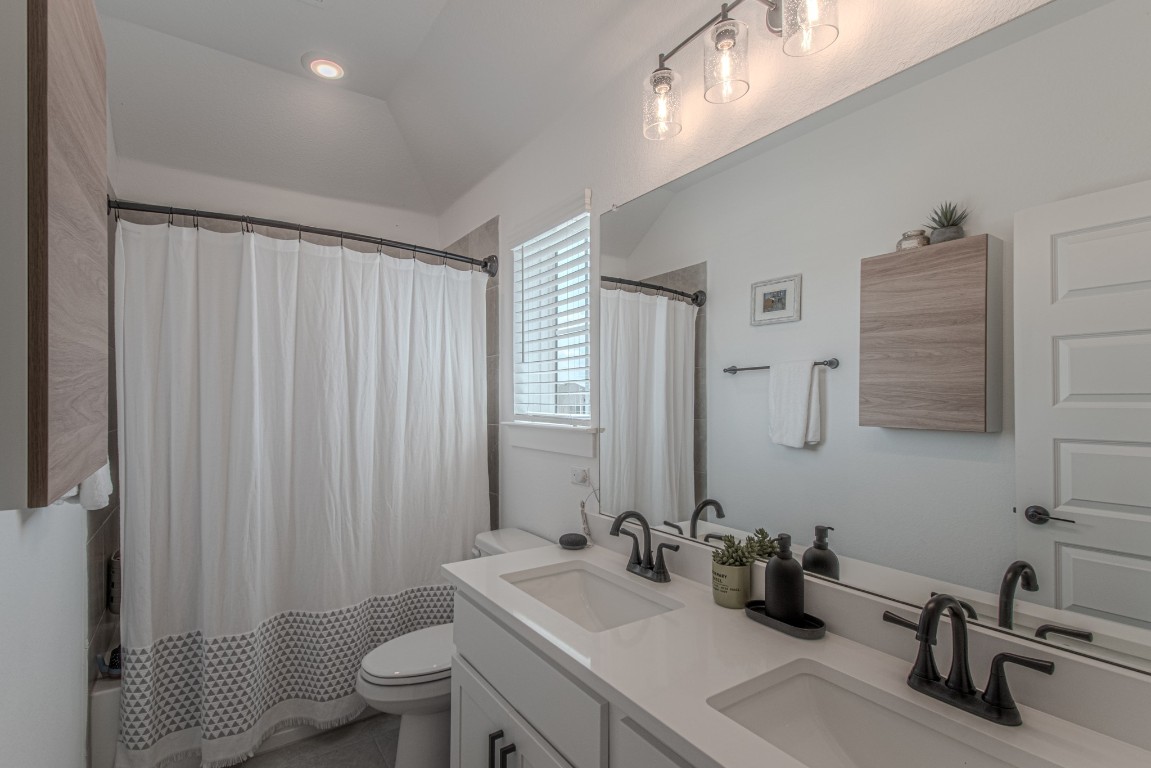 308 Millbend Road Georgetown, TX 78633 - Photo 31 of 40 a bathroom with a sink a toilet and mirror