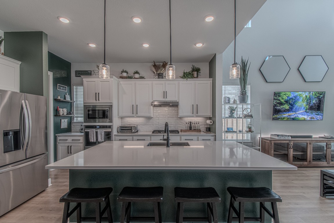 308 Millbend Road Georgetown, TX 78633 - Photo 7 of 40 a kitchen with stainless steel appliances a dining table chairs refrigerator and microwave