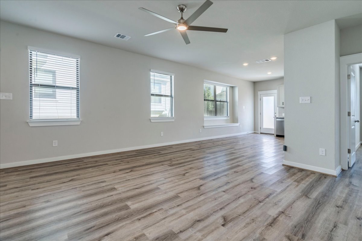 144 Threshing Road, Unit A Buda, TX 78610 - Photo 7 of 35 Living room with ceiling fan and tv mount. LVP flooring throughout the lower level.