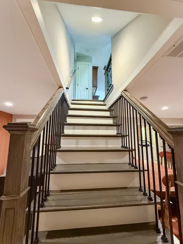 a view of a hallway with wooden floor and a living room